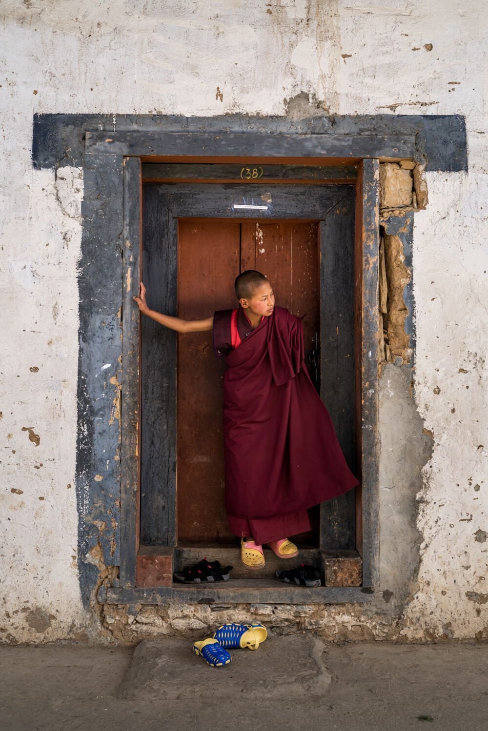 Monk on a doorway in Bhutan